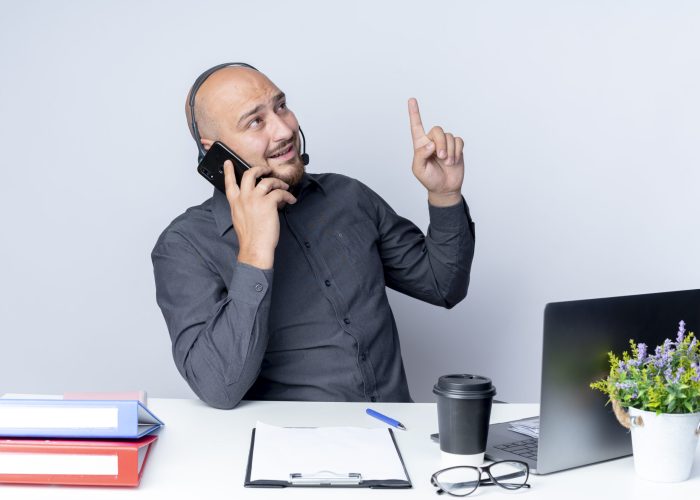 impressed young bald call center man wearing headset sitting at desk with work tools talking on phone raising finger and looking at side isolated on white background SSUCv3H4sIAAAAAAAACpyRz27DIAzG75P2DhHnRmr+dE36KtUOxrAGlUIFZNNU9d1nIFScd8M/25/9mcf7W9MwDl4hOzWPGFGstF59cBCUNYT3u407aYR0NZFCBesU6BpyCLgYuEmCZtU64mdKMh8grF76OGxDCEFeSCPDl0Te6JzjpiRSkjooxdiuYn7liRWUxf/VmR+fxQ1cpMHftHBlxEktIRs551J2/QnS3WprsAplK1ffFkHHgqFSujuFylyqNhuWdOXShnY1wcUVXpszbe0duI4n/iJNWfgC3lO5KLwahPSn9lbNMTYkA5sqE/QTMeyGfjwO3dR/zIf9NPbTvBXk31sU6aR1ihDFeFWitq7iBmzs+WE+ct6iOI7tiLxrOU5dO3E87DsxiVl0dPjnHwAAAP//AwC8CH2ihwIAAA==